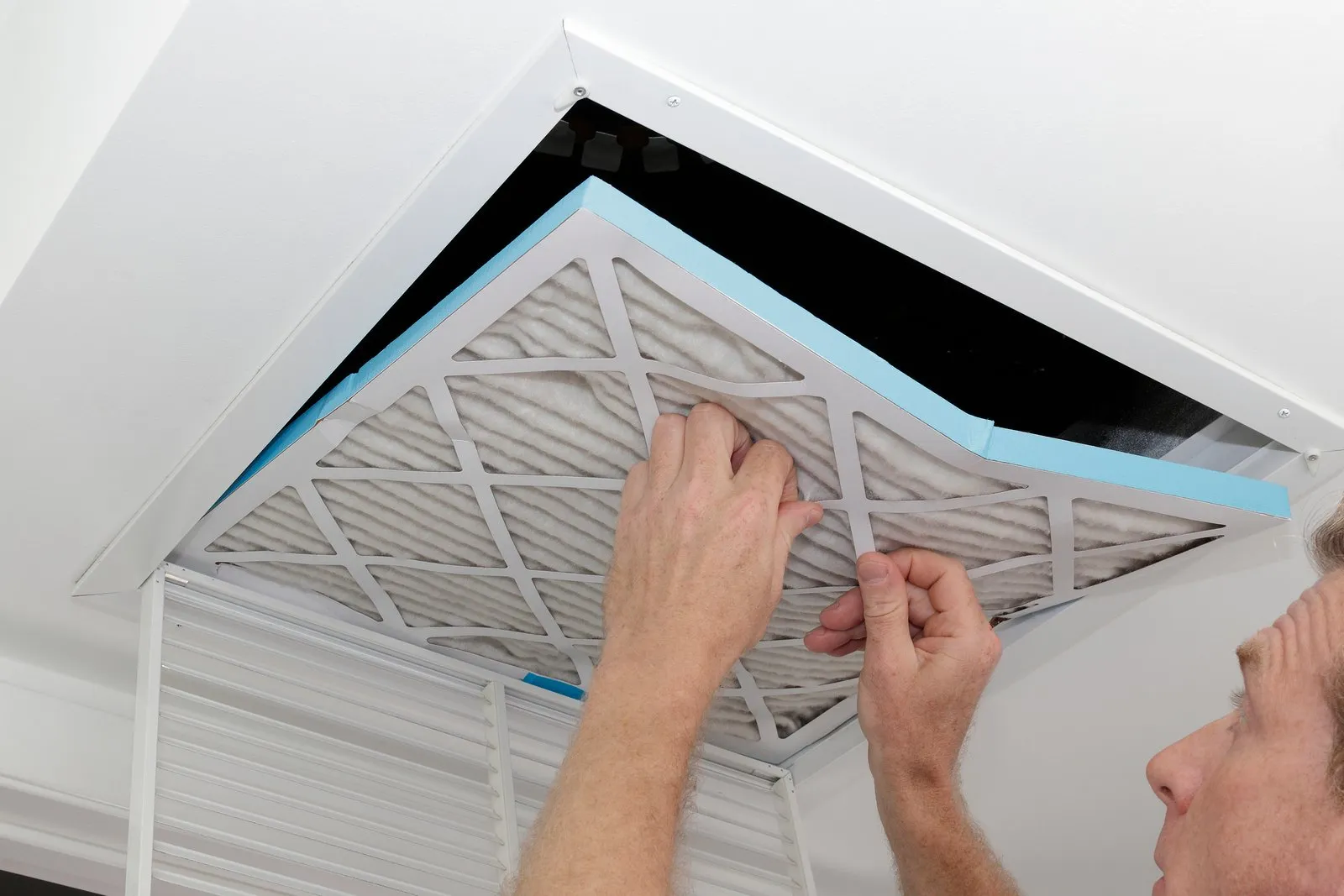 Technician cleaning an air duct vent in a Renton home